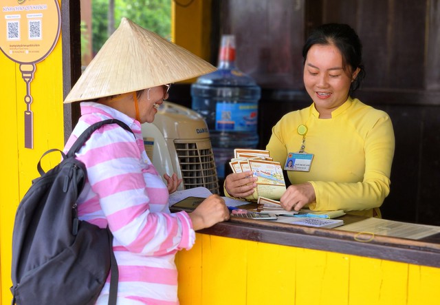 A guide buys tickets for the group before entering the old town