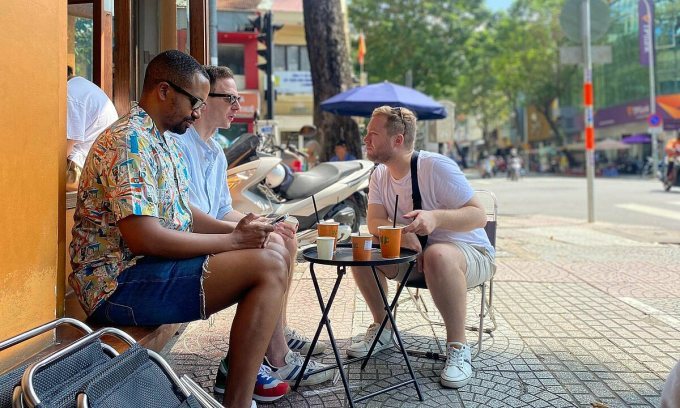 Foreign tourists drink coffee on a sidewalk in HCMC, October 2022. Photo by VnExpress/Khoa Lai